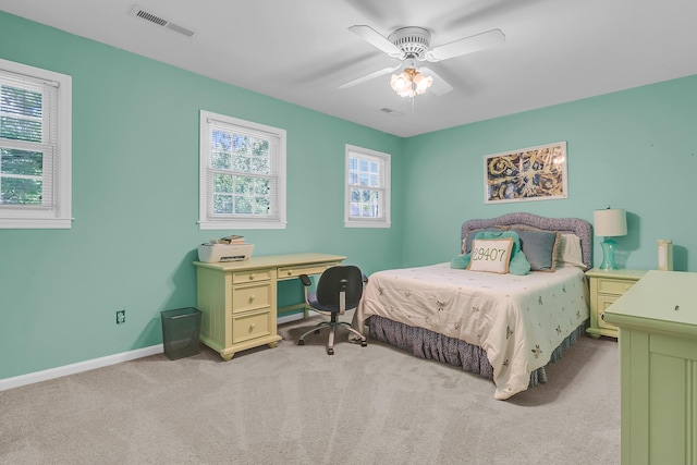 bedroom with light colored carpet, baseboards, and a ceiling fan