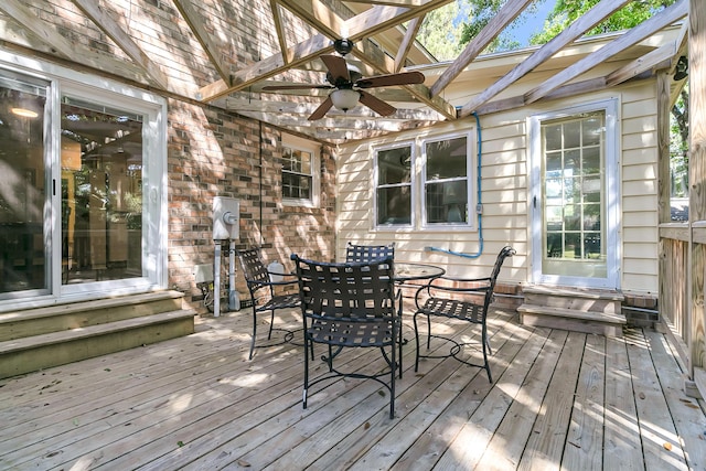 wooden deck featuring a ceiling fan, entry steps, and outdoor dining area