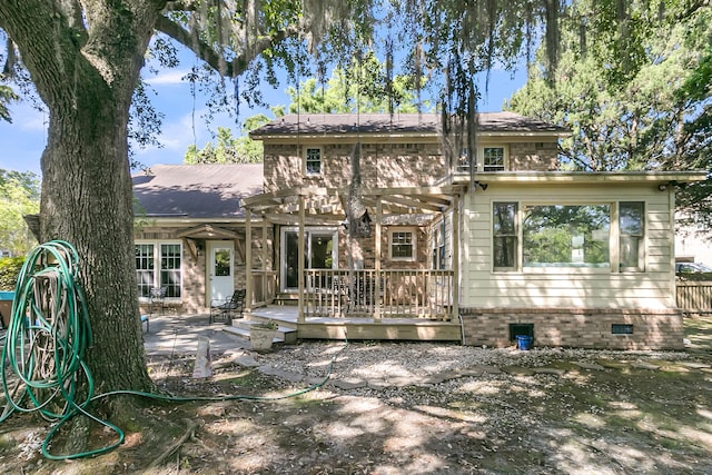 rear view of property with a wooden deck, a patio, and crawl space