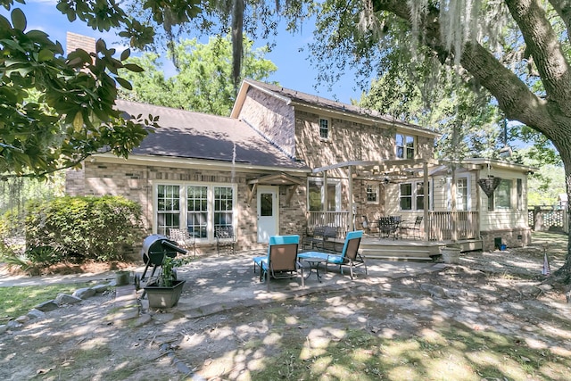rear view of house with a pergola and a wooden deck