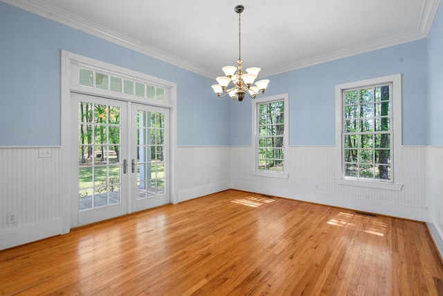 unfurnished room with an inviting chandelier, visible vents, hardwood / wood-style floors, wainscoting, and french doors