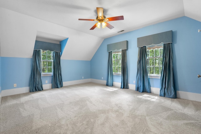 additional living space with baseboards, vaulted ceiling, carpet flooring, visible vents, and ceiling fan