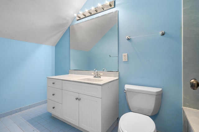 bathroom featuring baseboards, toilet, vanity, vaulted ceiling, and tile patterned flooring