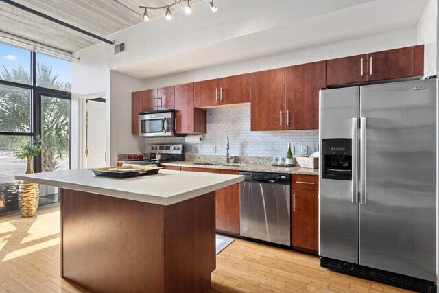 1 Cool Blow St Unit 124, Charleston, SC 29403 - kitchen with appliances with stainless steel finishes, a sink, light countertops, tasteful backsplash, and light wood finished floors
