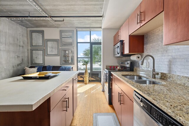 1 Cool Blow St Unit 124, Charleston, SC 29403 - kitchen with appliances with stainless steel finishes, a sink, light wood-style flooring, tasteful backsplash, and open floor plan
