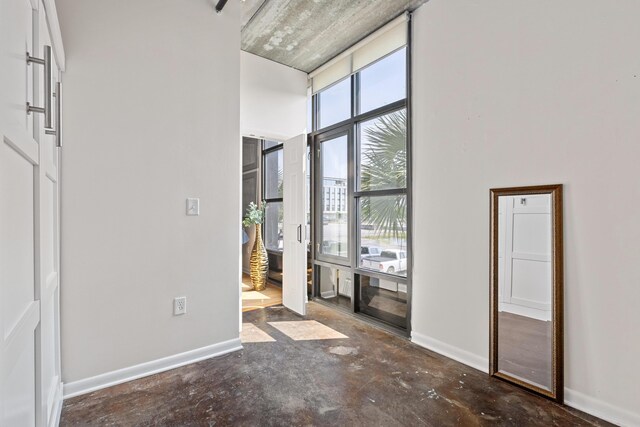 1 Cool Blow St Unit 124, Charleston, SC 29403 - foyer entrance featuring unfinished concrete floors, baseboards, and a towering ceiling
