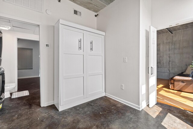 1 Cool Blow St Unit 124, Charleston, SC 29403 - unfurnished bedroom with concrete floors, stacked washer / drying machine, and baseboards