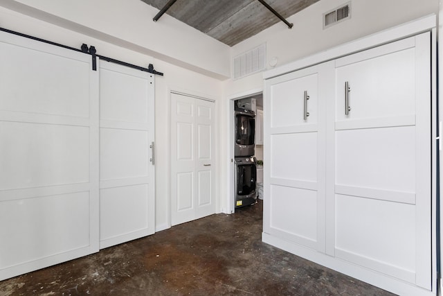 1 Cool Blow St Unit 124, Charleston, SC 29403 - unfurnished bedroom with estacked washer and dryer, concrete flooring, and a barn door