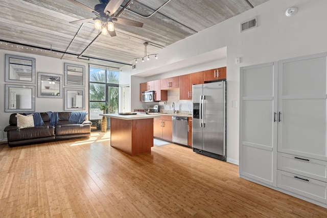 1 Cool Blow St Unit 124, Charleston, SC 29403 - kitchen with stainless steel appliances, light countertops, ceiling fan, decorative backsplash, and a kitchen island