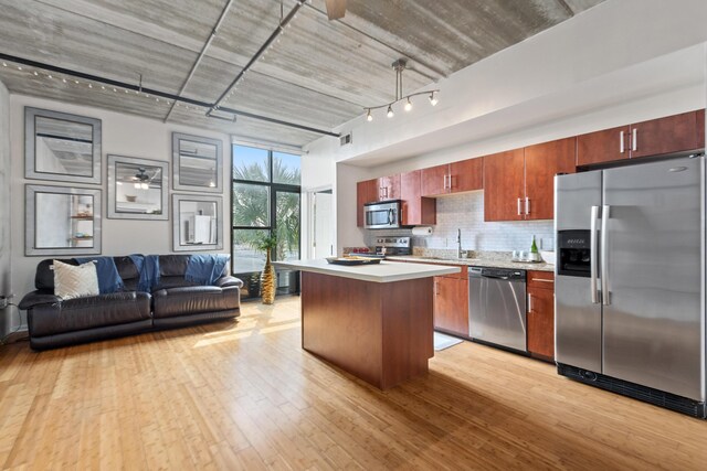1 Cool Blow St Unit 124, Charleston, SC 29403 - kitchen featuring appliances with stainless steel finishes, a kitchen island, light countertops, a sink, and light wood-style floors