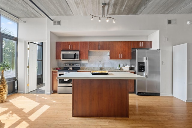 1 Cool Blow St Unit 124, Charleston, SC 29403 - kitchen featuring stainless steel appliances, track lighting, a sink, light countertops, and decorative backsplash