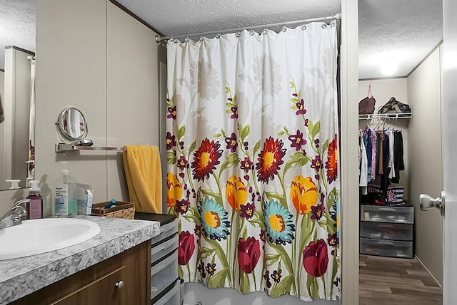 bathroom featuring vanity, hardwood / wood-style floors, and a textured ceiling