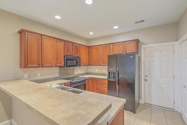 kitchen featuring sink, light tile patterned floors, black appliances, and kitchen peninsula