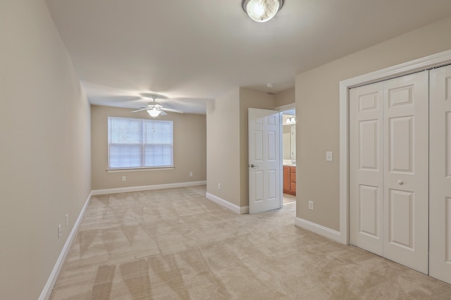 unfurnished bedroom with light carpet, a closet, and ceiling fan