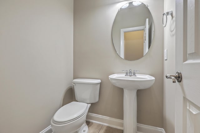 bathroom featuring sink, toilet, and tile patterned flooring