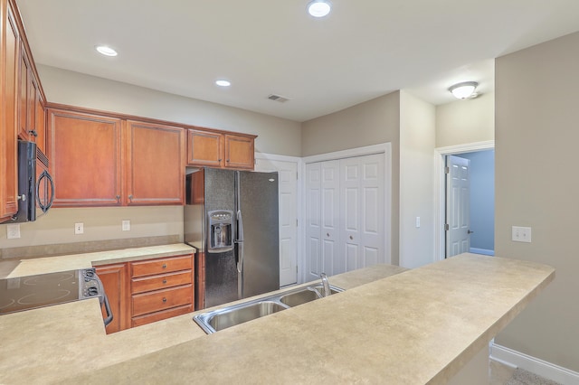 kitchen featuring black appliances, kitchen peninsula, and sink