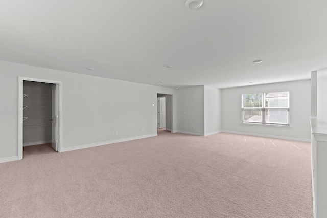 spare room with light carpet and baseboards
