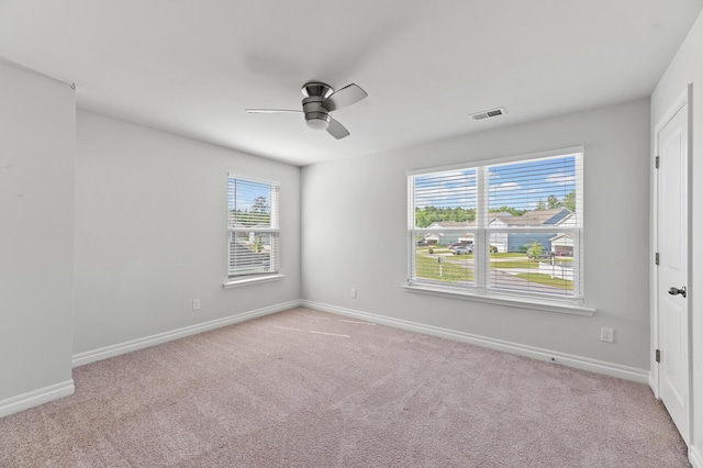 unfurnished room featuring ceiling fan, healthy amount of natural light, and carpet