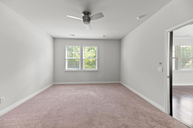 carpeted empty room featuring ceiling fan, a smoke detector, and baseboards