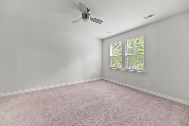 empty room with a ceiling fan, baseboards, and light carpet
