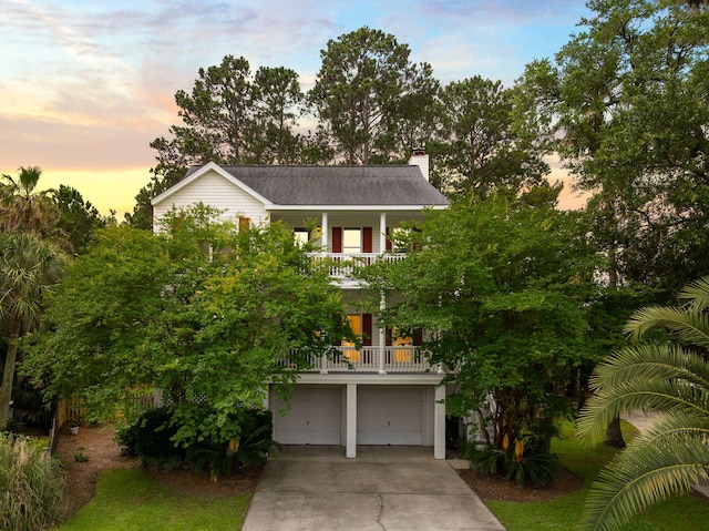 1417 S Jetties Ct, Mount Pleasant, SC 29466 - coastal home with a balcony, driveway, a garage, and a chimney