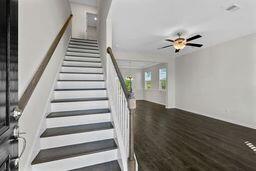 staircase with ceiling fan and hardwood / wood-style flooring