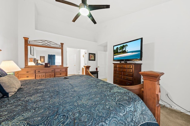carpeted bedroom featuring a ceiling fan and a high ceiling