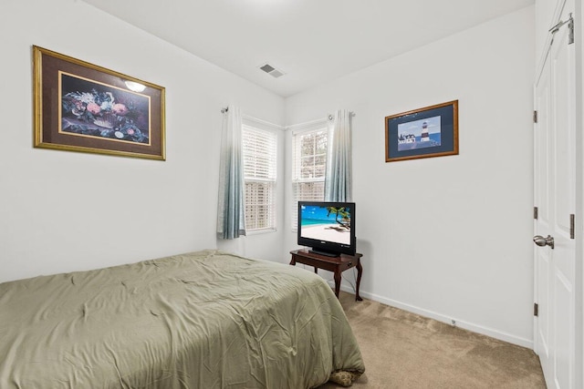 bedroom with baseboards, visible vents, and light colored carpet