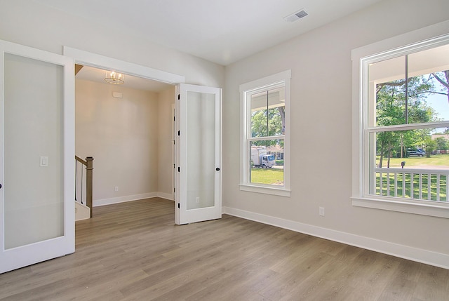 empty room featuring baseboards, light wood finished floors, and a healthy amount of sunlight