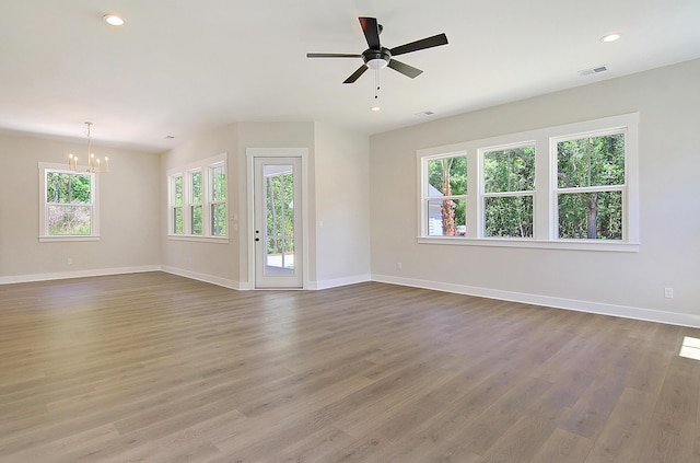 unfurnished living room featuring light hardwood / wood-style floors and ceiling fan with notable chandelier