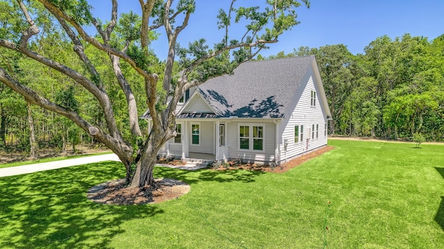 view of front of property featuring a shingled roof and a front lawn