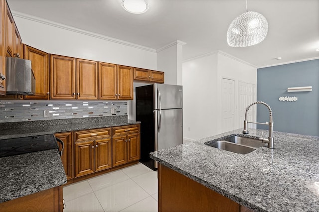 kitchen featuring decorative backsplash, dark stone countertops, sink, stainless steel appliances, and hanging light fixtures