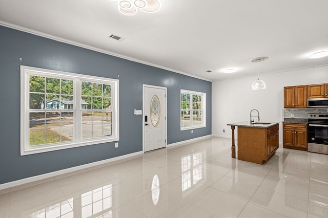 kitchen featuring light tile patterned floors, a center island with sink, stainless steel appliances, and sink