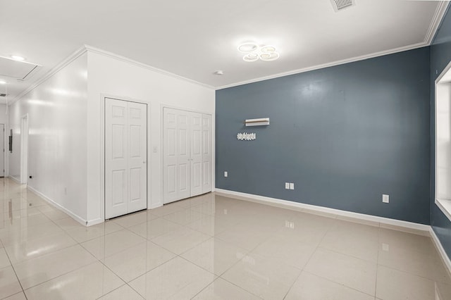 unfurnished bedroom featuring multiple closets, ornamental molding, and light tile patterned floors