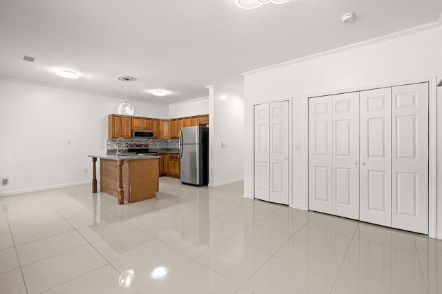 kitchen featuring pendant lighting, light tile patterned flooring, a center island with sink, stainless steel appliances, and crown molding