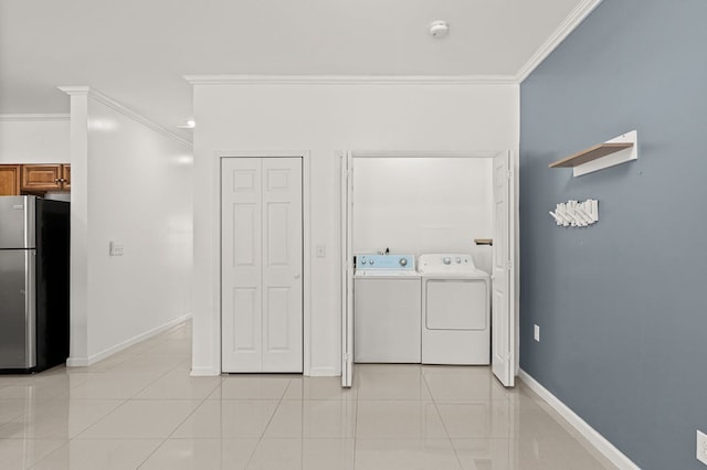 washroom featuring light tile patterned flooring, crown molding, and washer and clothes dryer