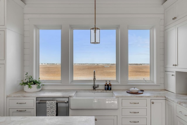 kitchen featuring sink, plenty of natural light, hanging light fixtures, and white cabinets