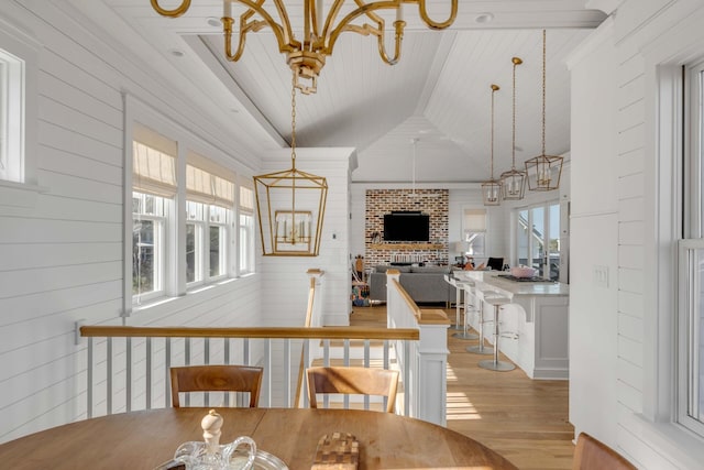 dining space featuring lofted ceiling, a chandelier, and light hardwood / wood-style flooring