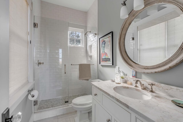 bathroom with vanity, toilet, and a shower with door