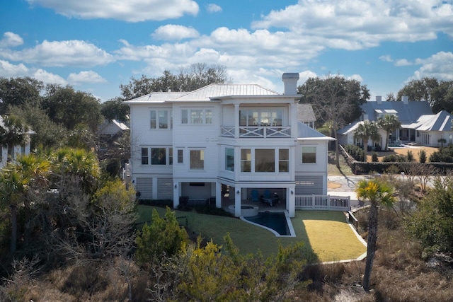 rear view of property featuring a lawn and a balcony