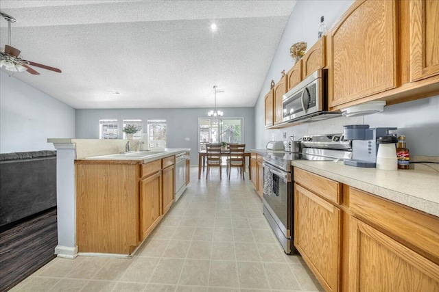 kitchen with stainless steel appliances, a textured ceiling, vaulted ceiling, and light countertops