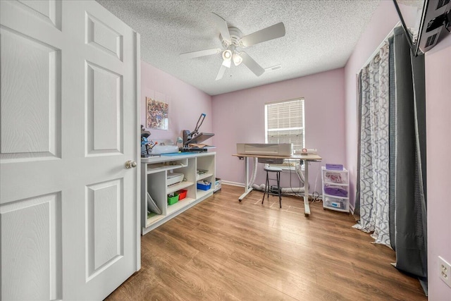 office space featuring ceiling fan, a textured ceiling, and wood finished floors