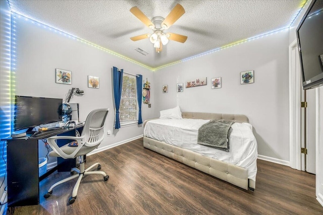 bedroom with visible vents, baseboards, wood finished floors, a textured ceiling, and a ceiling fan