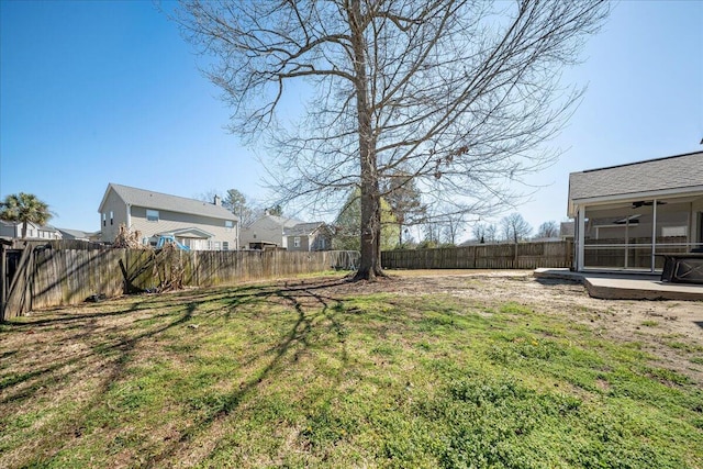 view of yard with a fenced backyard, a residential view, and ceiling fan