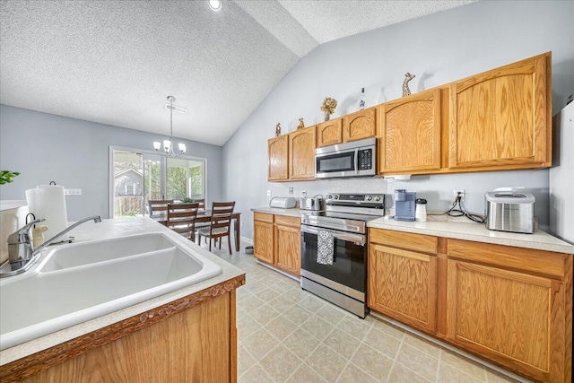 kitchen featuring a sink, lofted ceiling, a textured ceiling, and stainless steel appliances