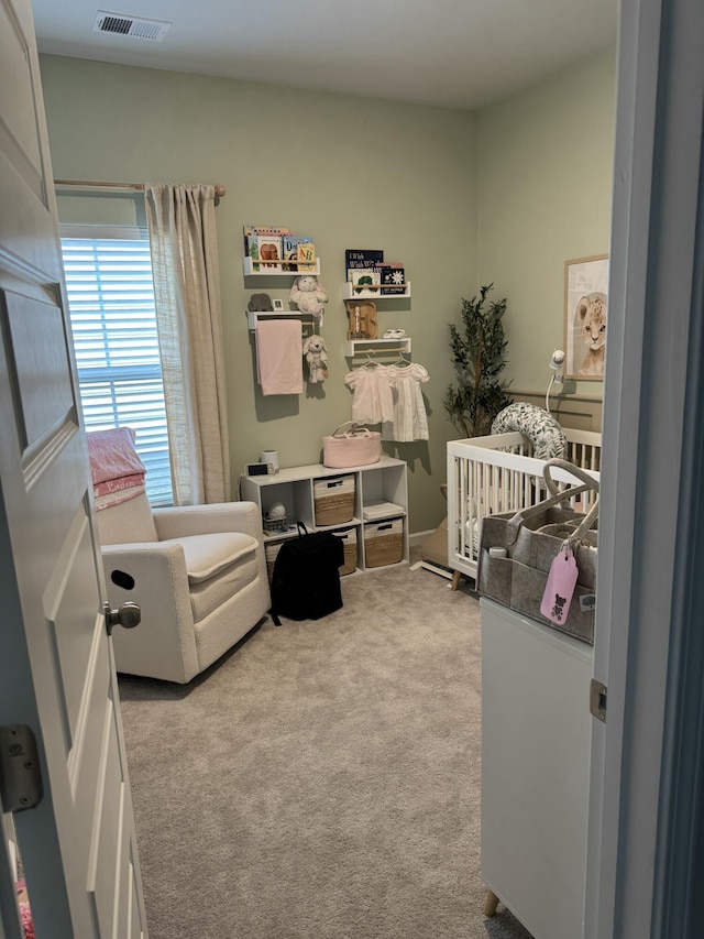 bedroom featuring light carpet, a nursery area, and visible vents