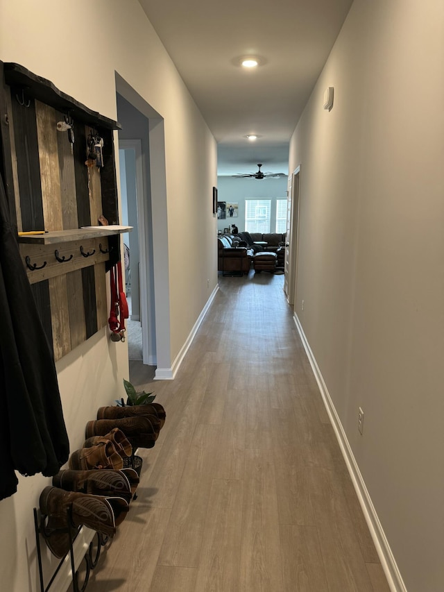 hallway featuring light wood-style floors and baseboards