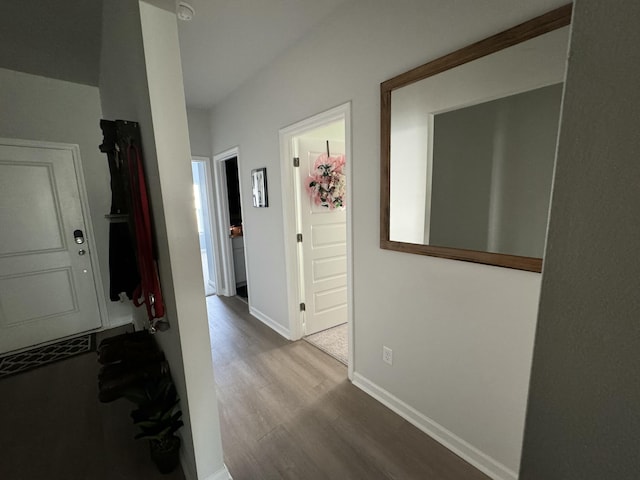 corridor with light wood-style flooring and baseboards