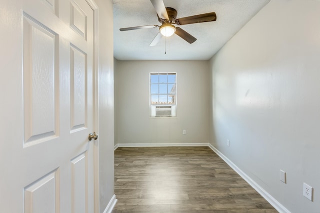 spare room with cooling unit, ceiling fan, dark hardwood / wood-style floors, and a textured ceiling