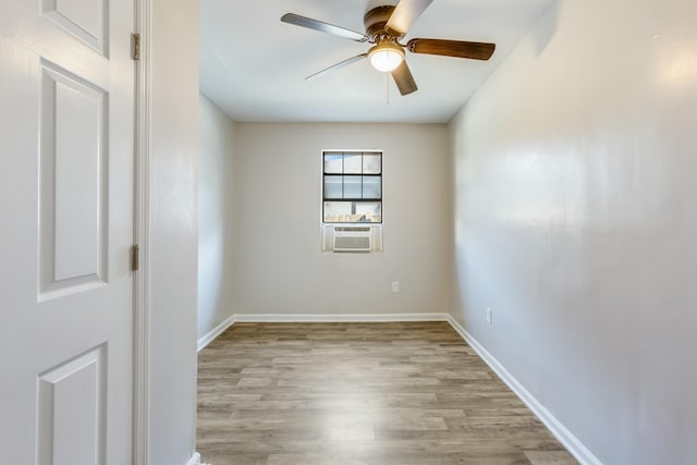 empty room featuring cooling unit, light hardwood / wood-style flooring, and ceiling fan